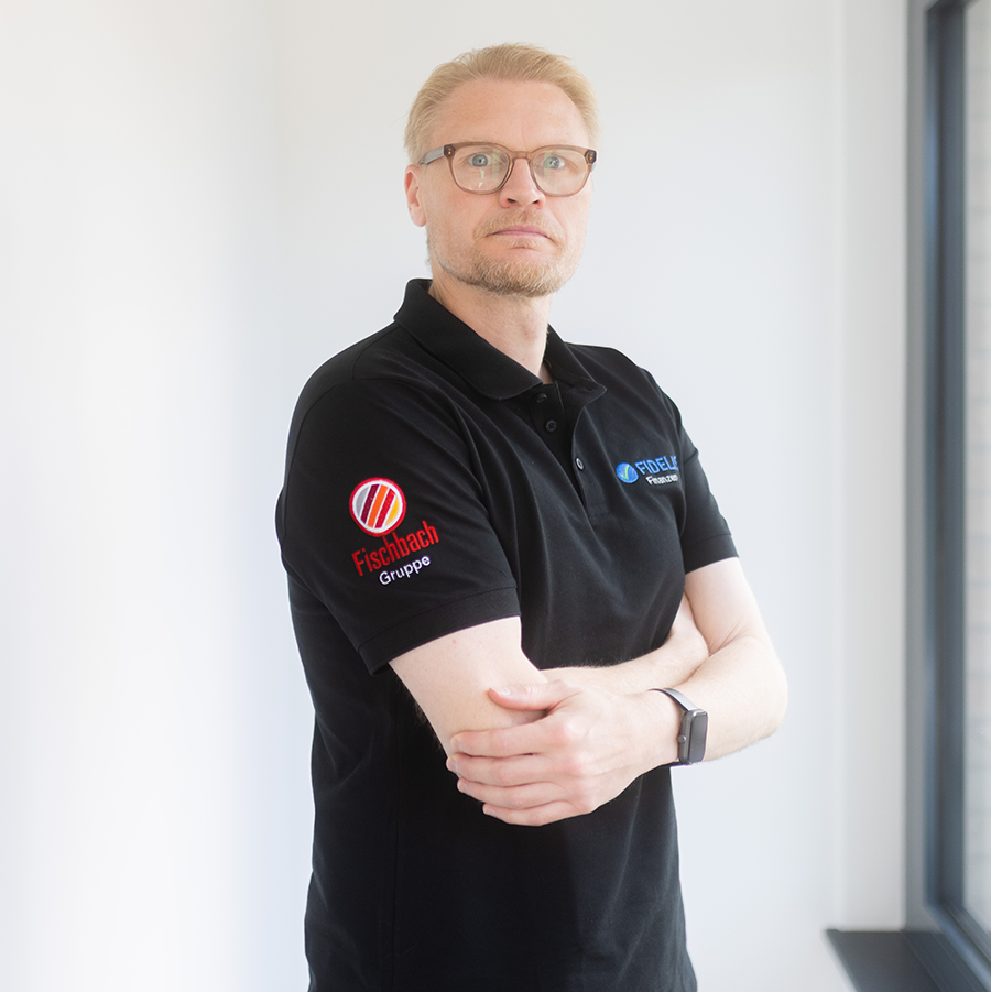 Dennis Tillmann steht vor einer weißen Wand