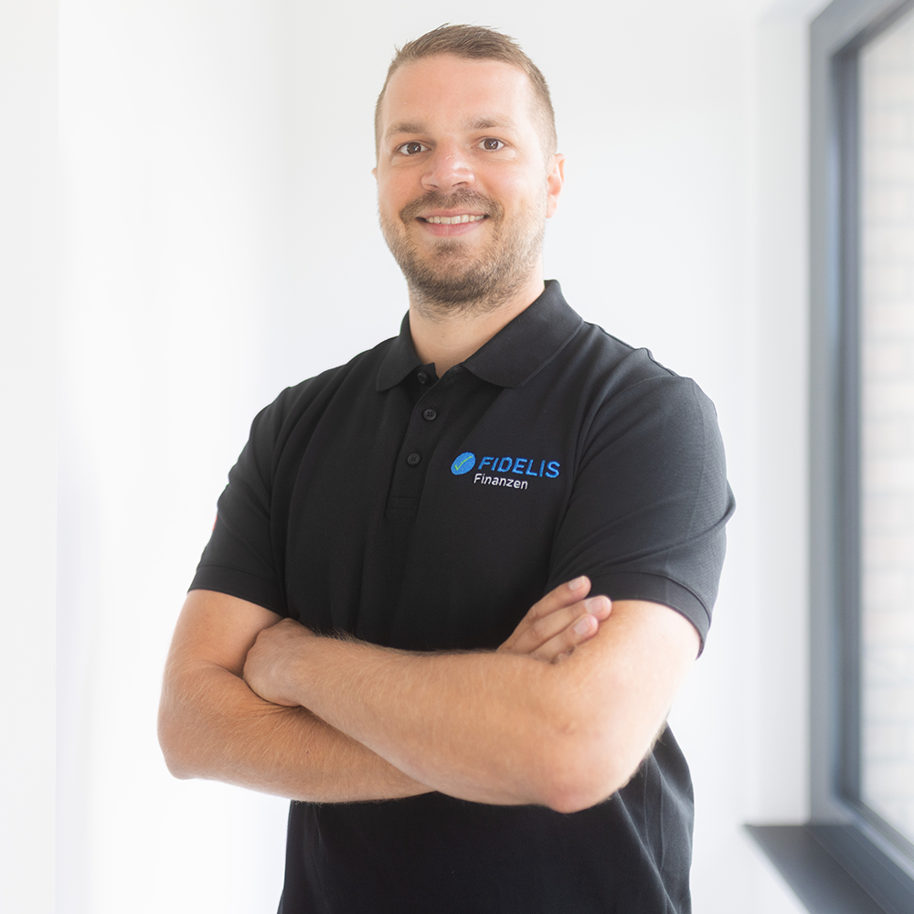 Sebastian Hahn steht vor einer weißen Wand