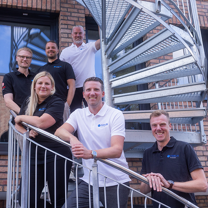 Das Team von Fidelis Finanzen auf einer Wendeltreppe